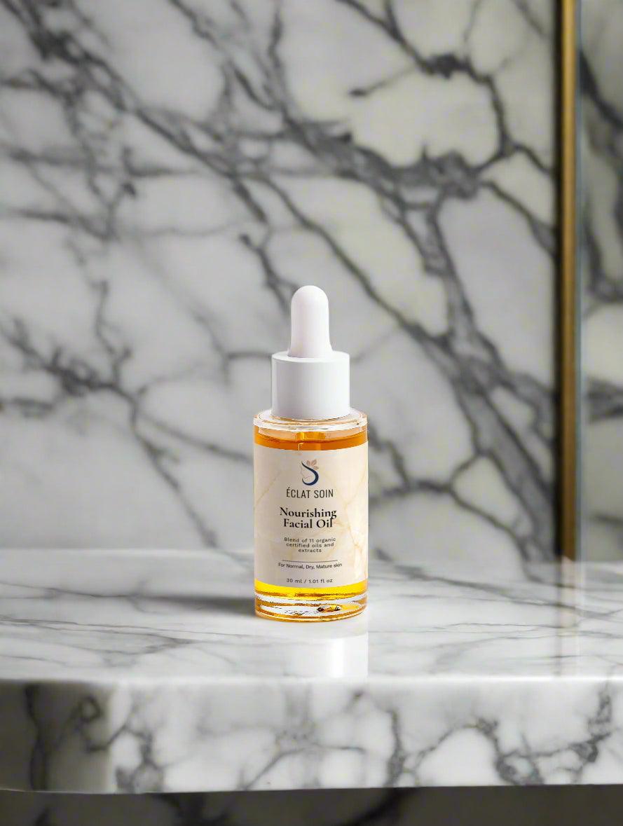 Eclat Soin Organic Nourishing Facial Oil in a glass dropper bottle on a marble surface